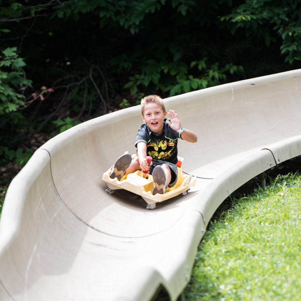 young boy waving on bromley mountain alpine slide 